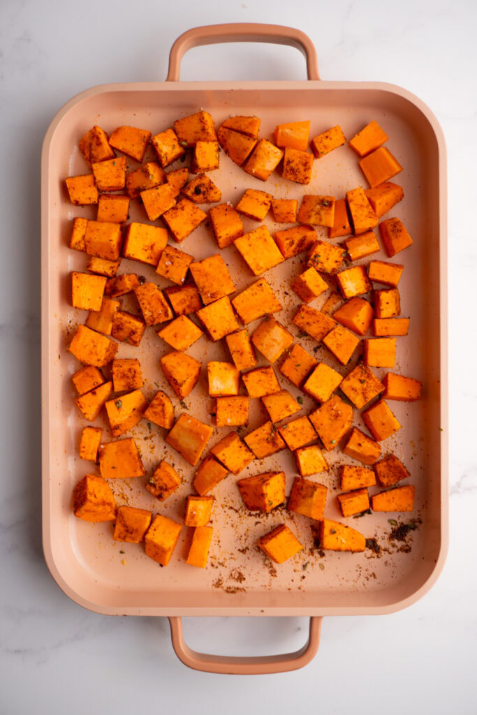 Diced sweet potatoes seasoned with taco seasoning before roasting.