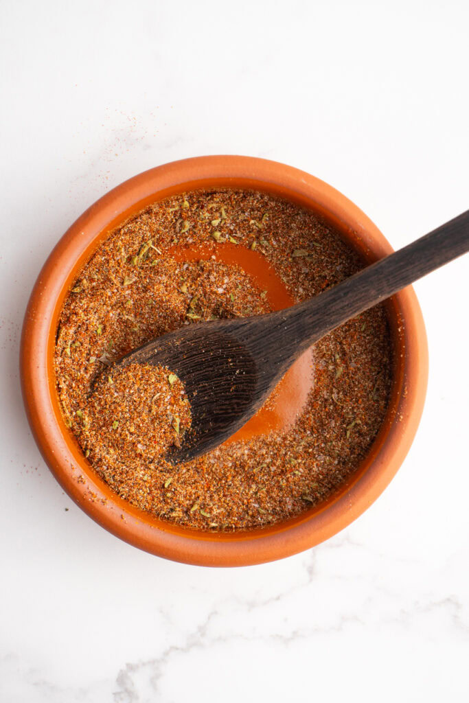 Overhead shot of homemade taco seasoning with a wooden spoon in the bowl.