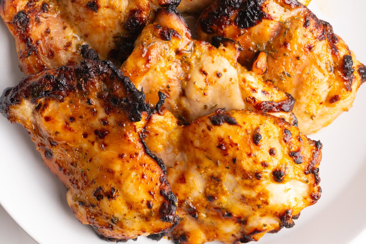 Close up of air fryer honey mustard chicken thighs in a bowl.