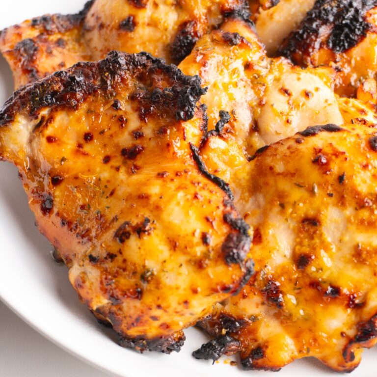 Honey mustard chicken thighs with one in the front with caramelized edges.