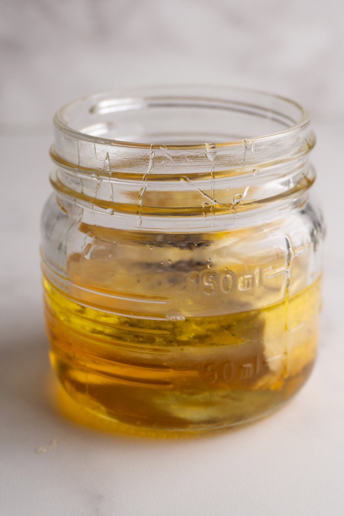 Ingredients needed to honey dijon vinaigrette in a jar before being combined.