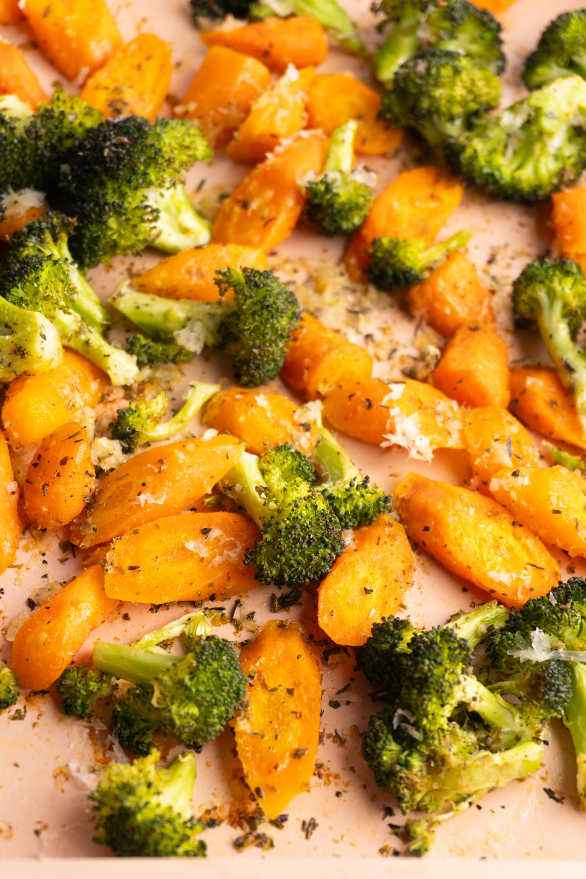 Roasted carrots and broccoli with parmesan on a sheet pan.