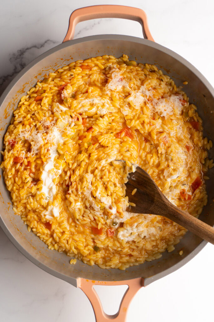 Stirring the cream and parmesan into the Cajun orzo.