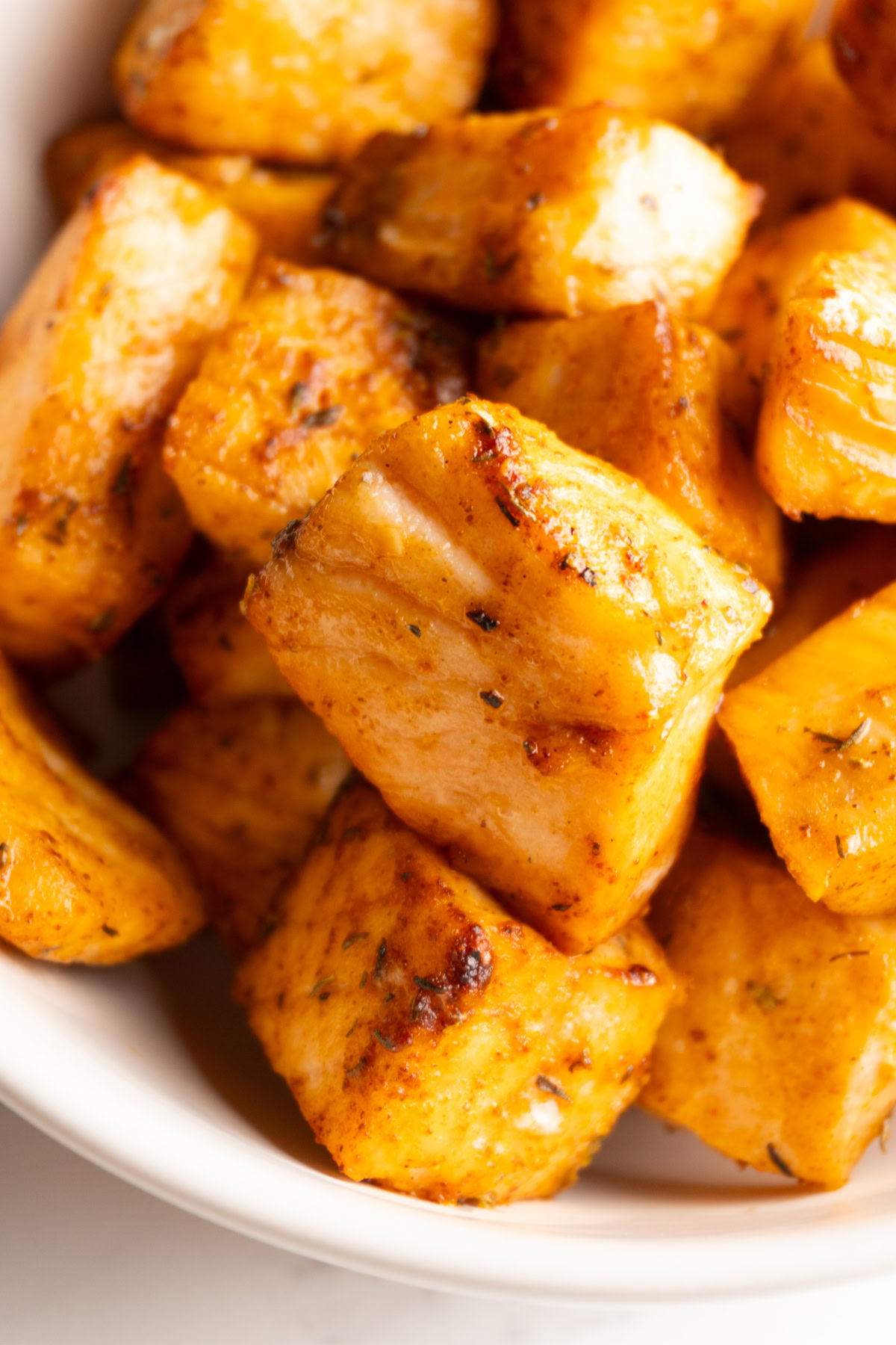 Close up of Cajun salmon bites served in a bowl.