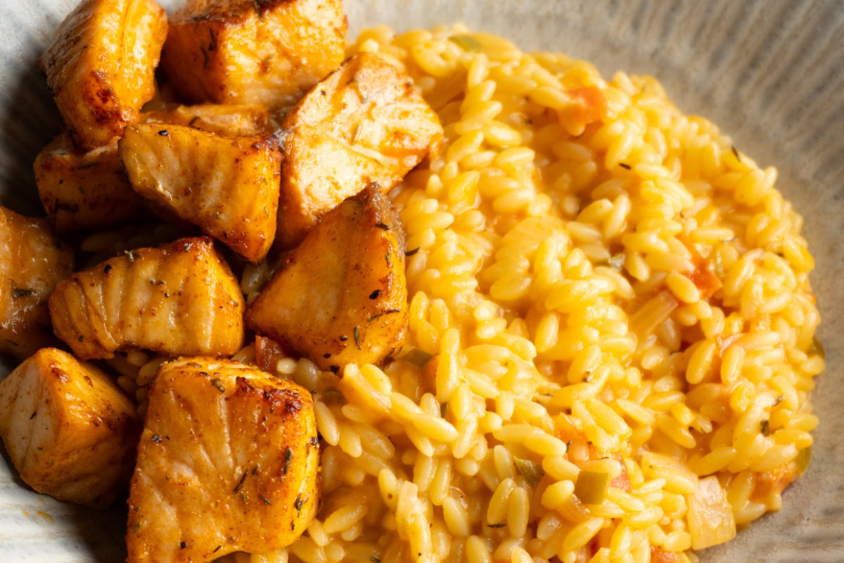 Close up of Cajun salmon bites served with cajun orzo in a bowl.