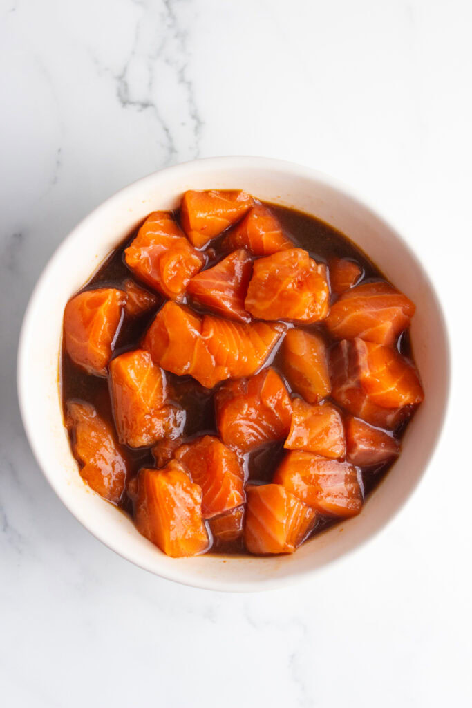 Overhead shot of fresh salmon in a poke bowl sauce.