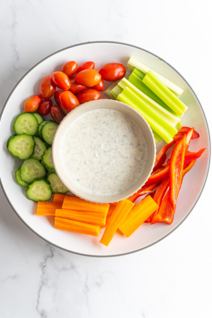 Healthy ranch served on a plate with a variety of fresh vegetables.
