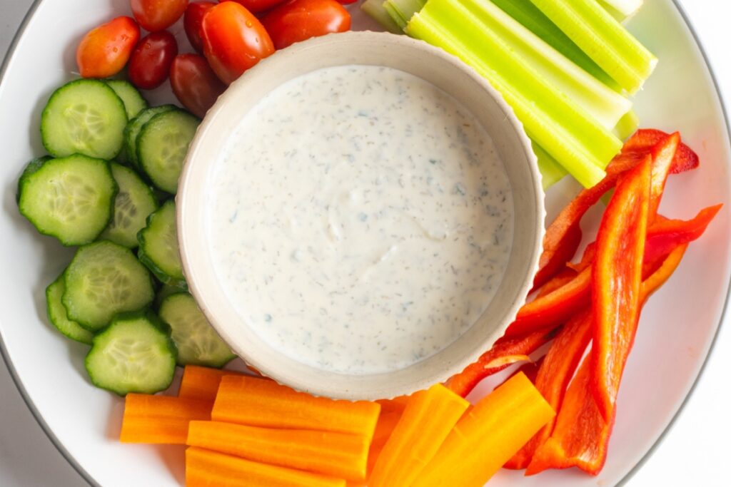 Healthy ranch in a small bowl served with fresh vegetables.