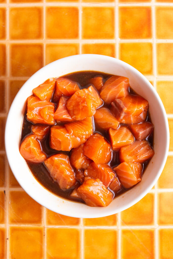 Salmon marinating in poke sauce.