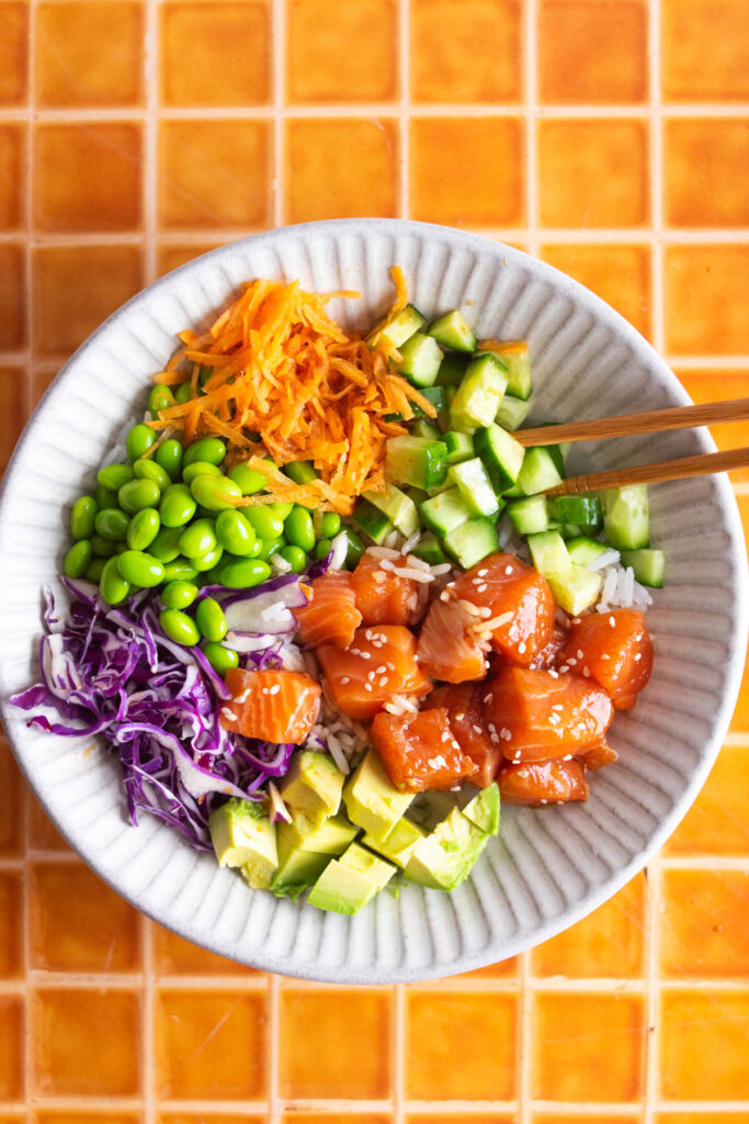 Finished salmon poke bowl with chopsticks.