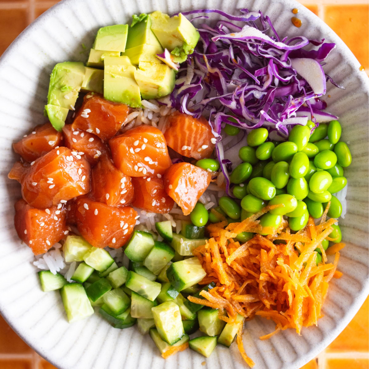 Overhead shot of a salmon poke bowl with vegetable toppings.
