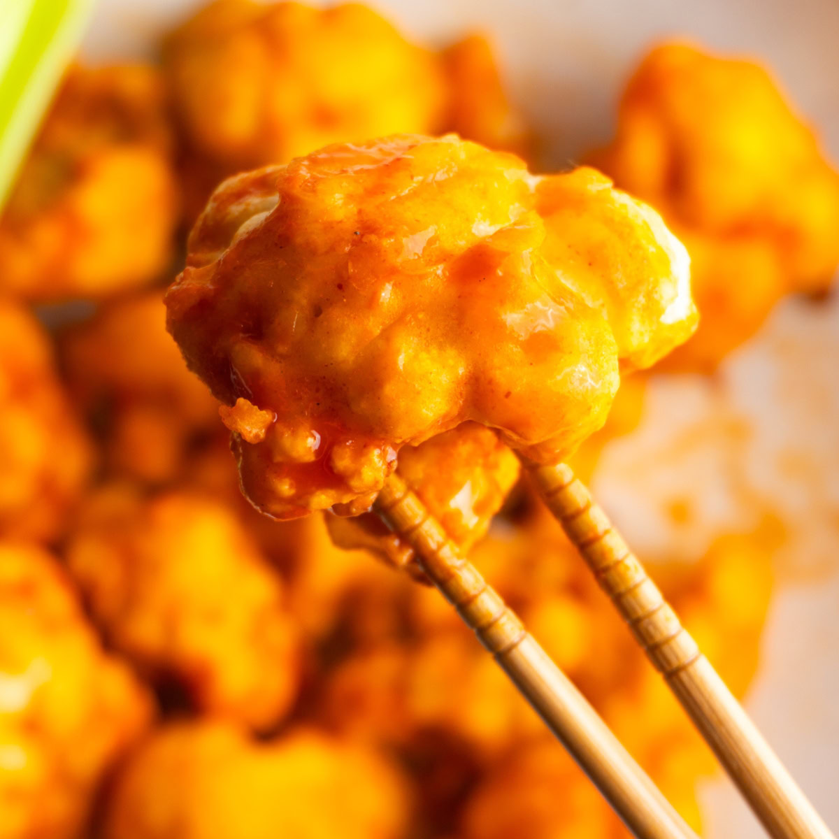 Piece of buffalo cauliflower being held by chopsticks.