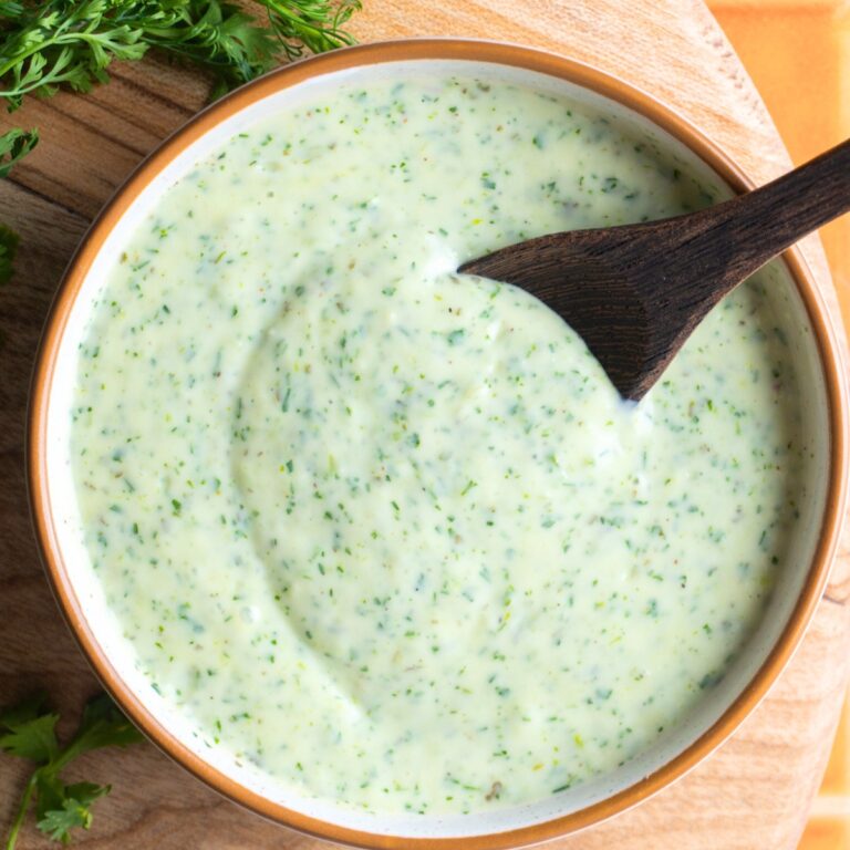 Cilantro ranch dressing in a bowl with a small wooden spoon.