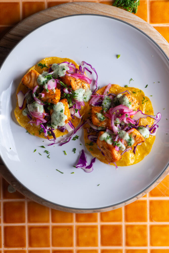 Two salmon tostadas served on a plate.
