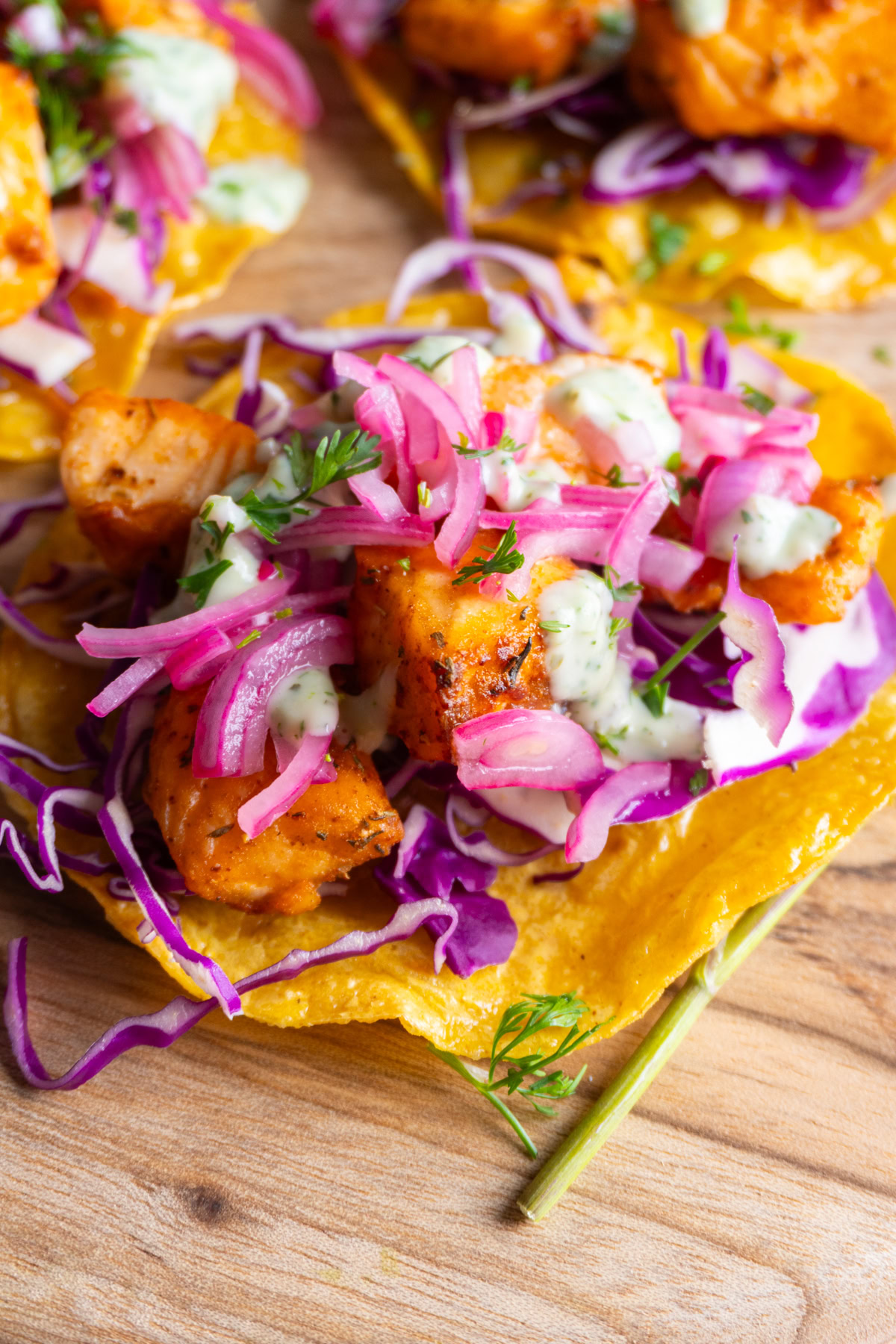 Side view of a salmon tostada on a wooden background.