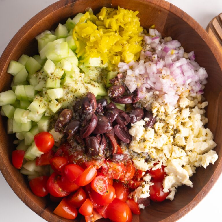 Overhead shot of a Greek couscous salad with ingredients on top before being mixed.