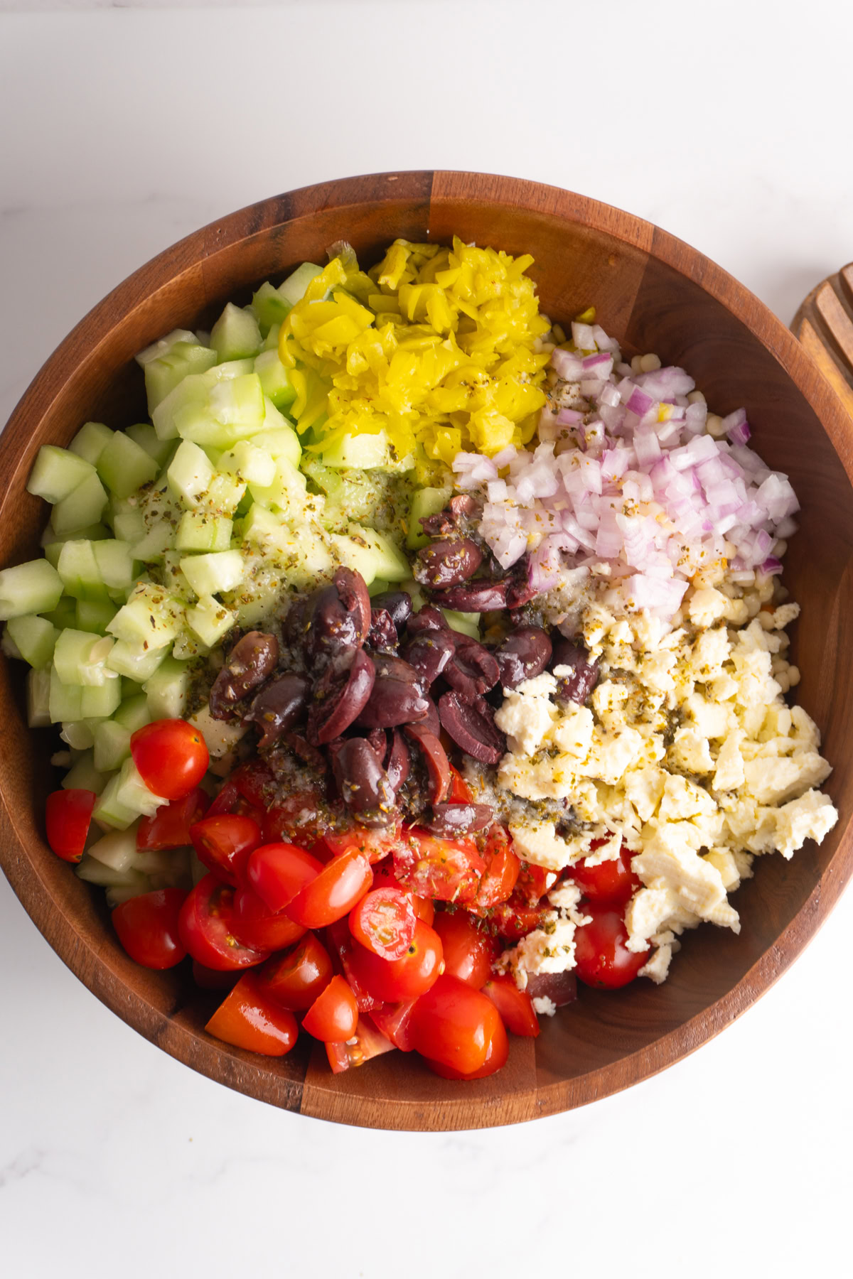 Dressing poured on top of the Greek couscous salad before mixing it all together.