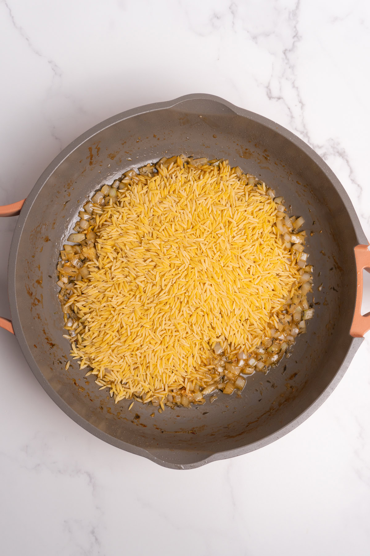 Dried orzo added to the onions and wine.