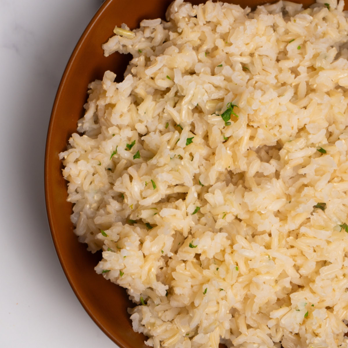 Close up of cilantro lime brown rice in a brown bowl.
